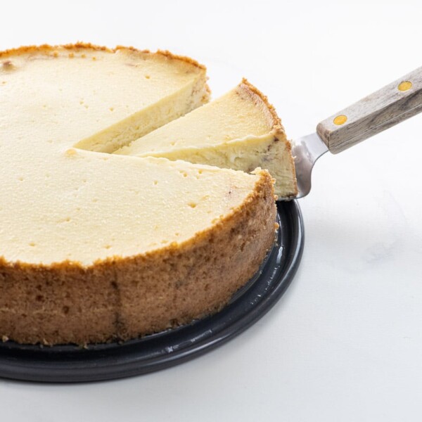 cinnamon roll cheesecake with a slice on a serving knife