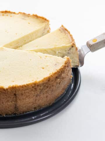 cinnamon roll cheesecake with a slice on a serving knife