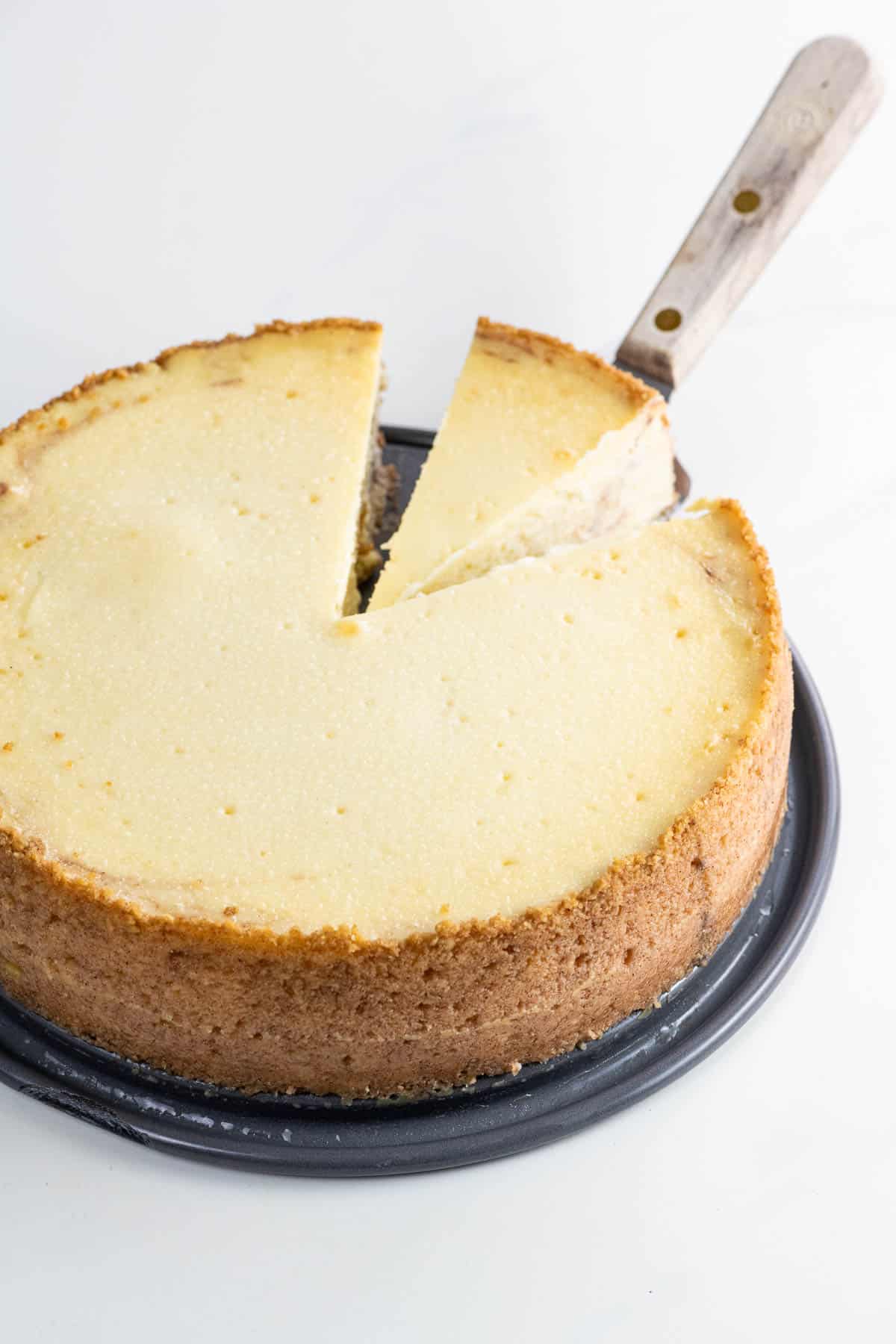 cinnamon roll cheesecake with a slice on a serving knife