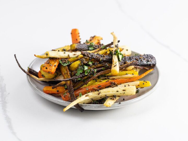 roasted rainbow carrots with cumin, mustard seed, and cilantro on a plate