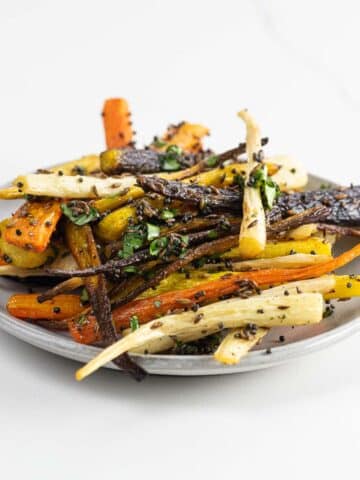 roasted rainbow carrots with cumin, mustard seed, and cilantro on a plate