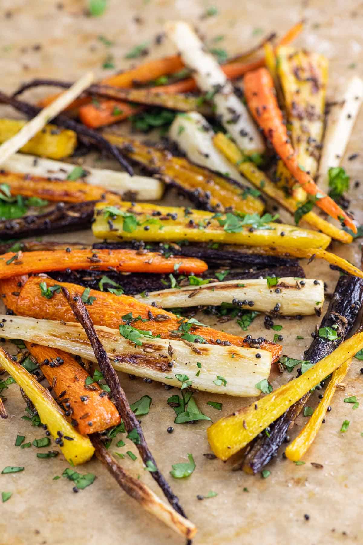 roasted rainbow carrots with cumin, mustard seed, and cilantro on a sheet pan