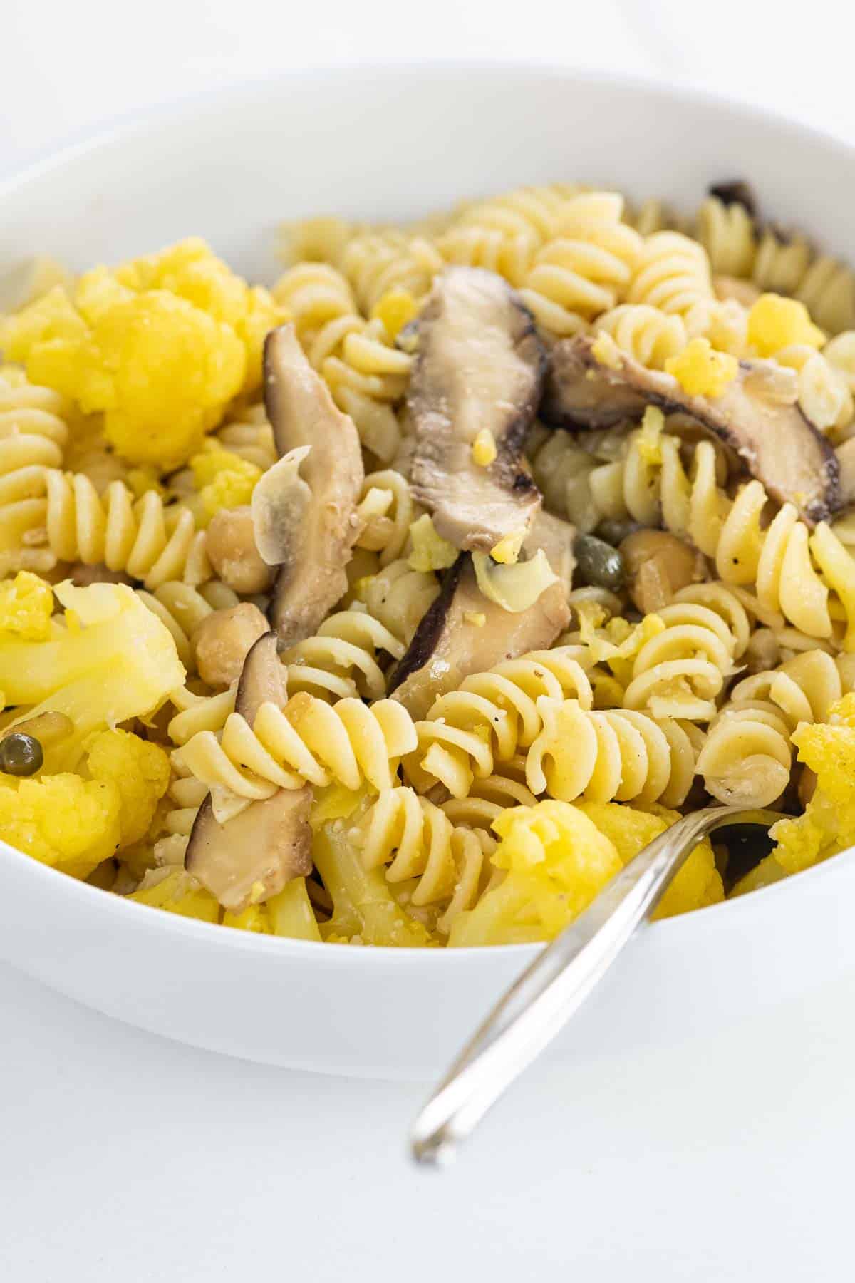 umami pasta with cauliflower, shiitakes, and chickpeas in a bowl