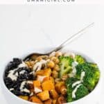 a black rice bowl with maple roasted butternut squash, sauteed chickpeas, broccoli, and tahini dressing