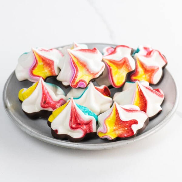 rainbow-colored chocolate meringue cookies on a plate