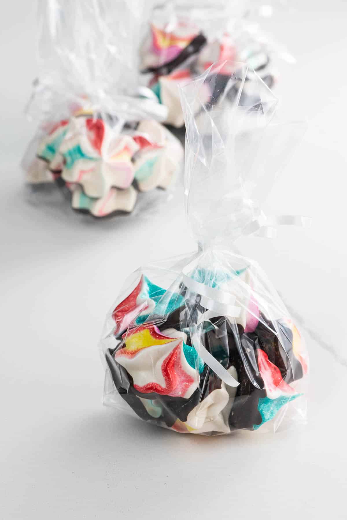 rainbow-colored chocolate meringue cookies in cellophane bags ready for gifting