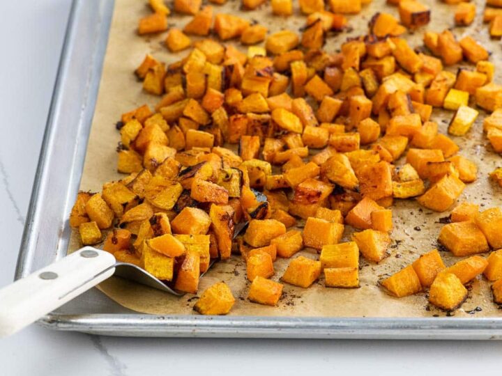 maple roasted butternut squash on a sheet pan with a spatula