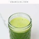 spinach juice with pineapple, green apple, and lime in a small glass