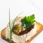white bean crostini with sun dried tomato, olive, parsley, and chives