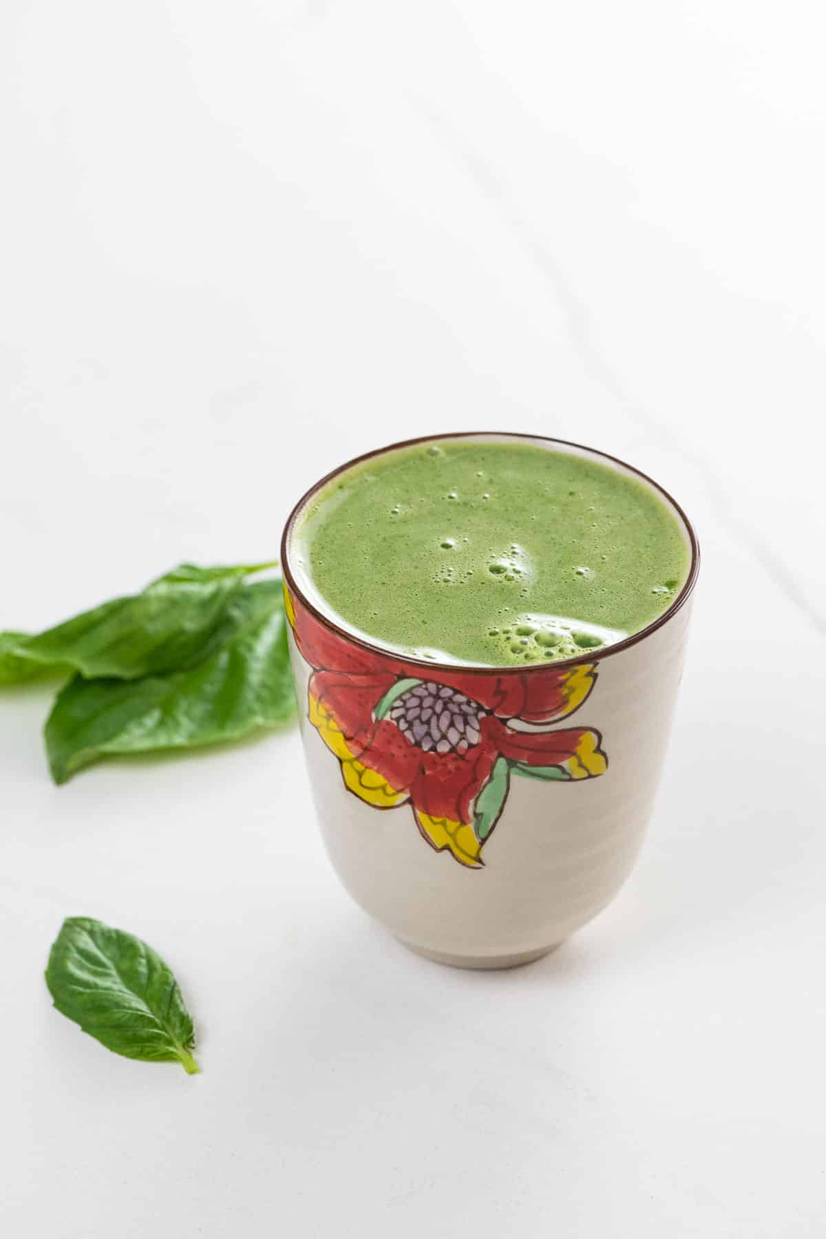 asian pear juice with basil, lemon, and celery in a decorative glass with basil leaves
