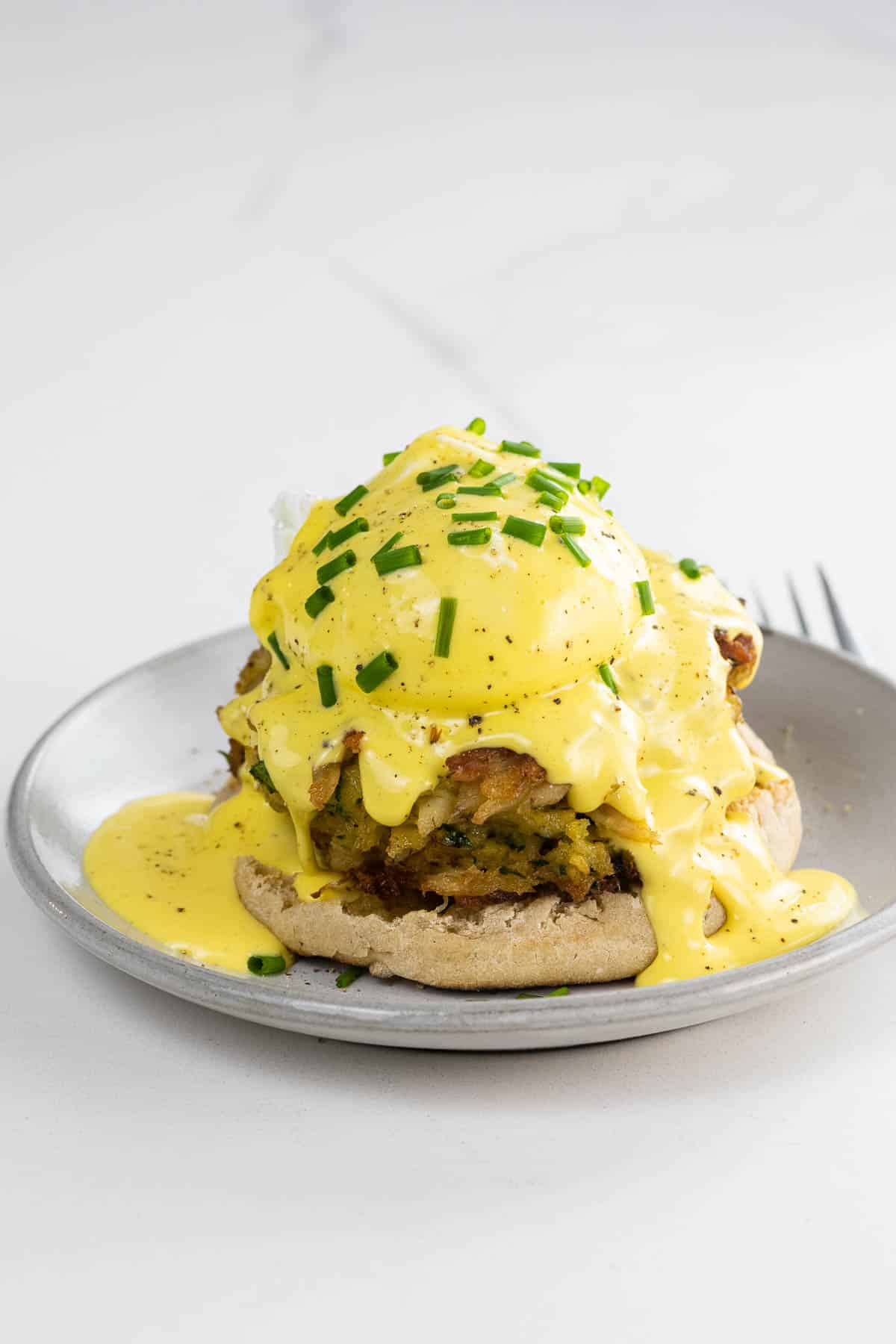 crab cake benedict on a small plate with a fork
