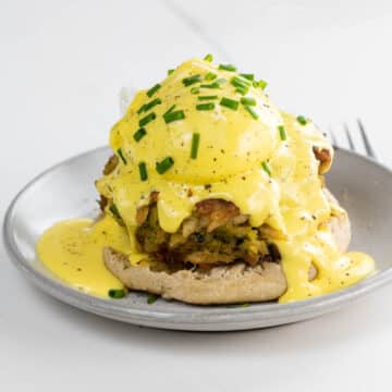crab cake benedict on a small plate with a fork