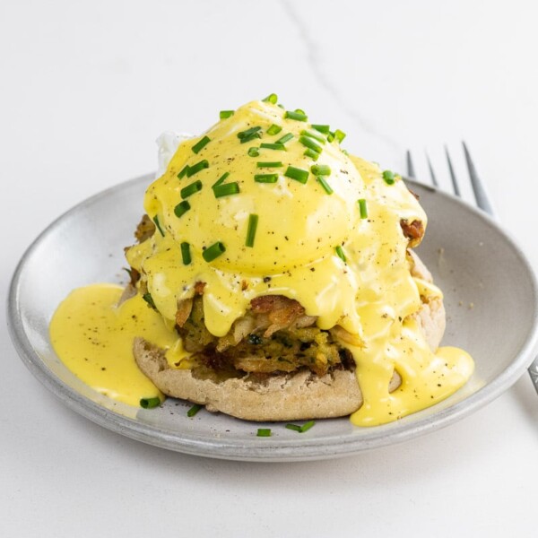 crab cake benedict on a small plate with a fork
