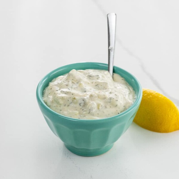 tartar sauce for crab cakes, fish, oysters, and more in a small bowl with a spoon and a lemon wedge
