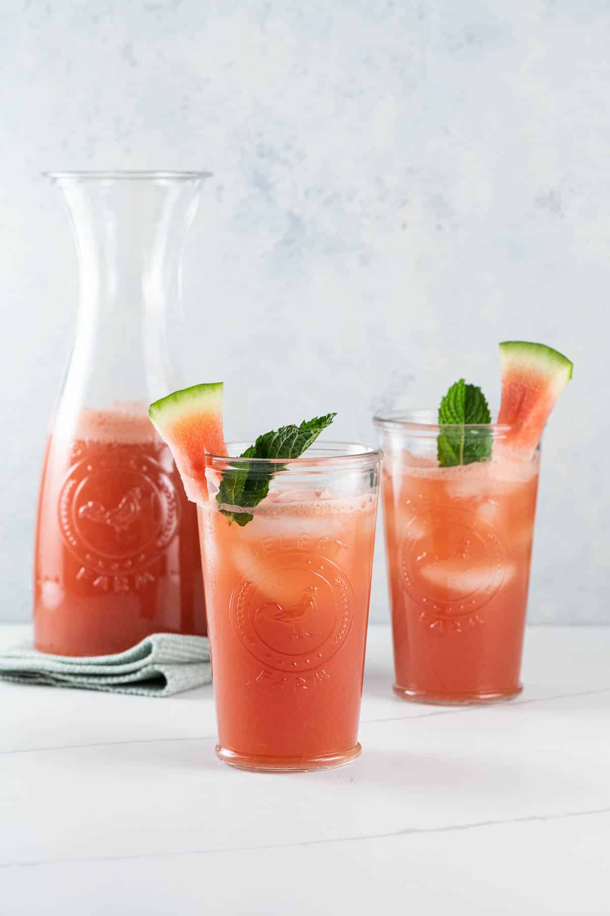 watermelon cucumber agua fresca in a pitcher and two glasses