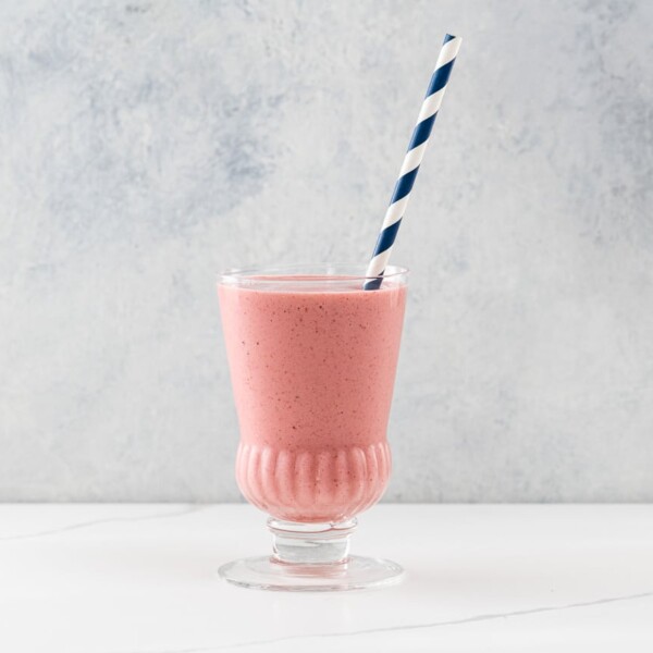 a strawberry lemonade smoothie in a glass with a straw