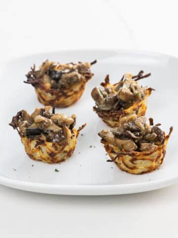 four potato nests filled with marsala mushrooms on a plate