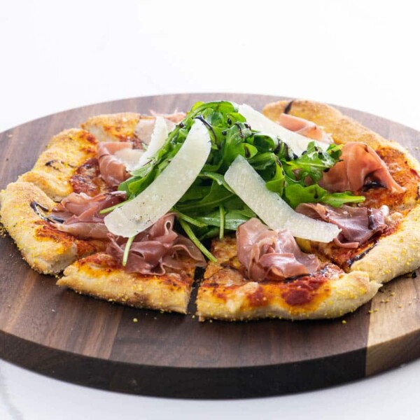 prosciutto and arugula pizza on a cutting board