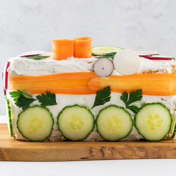 a smorgastarta (swedish sandwich cake) on a wooden serving platter