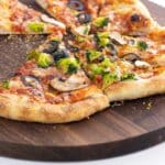 veggie supreme pizza slices on a cutting board