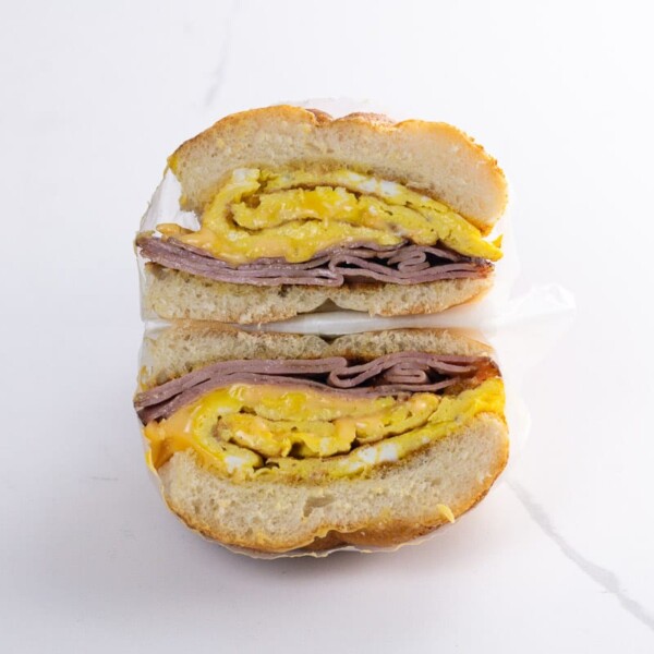 a ham egg and cheese sandwich on a kaiser roll wrapped in deli paper