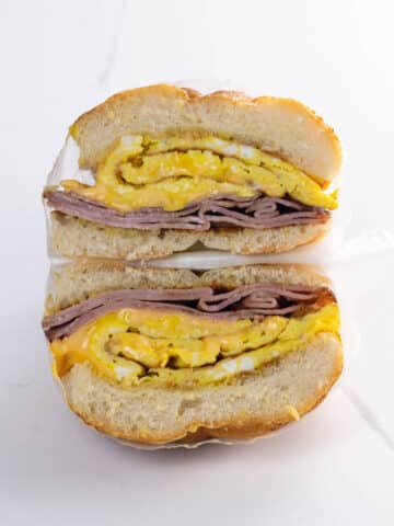 a ham egg and cheese sandwich on a kaiser roll wrapped in deli paper