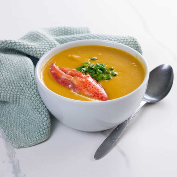 Maine lobster bisque in a bowl with a spoon and a napkin