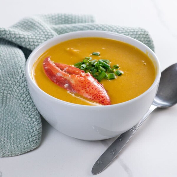 Maine lobster bisque in a bowl with a spoon and a napkin