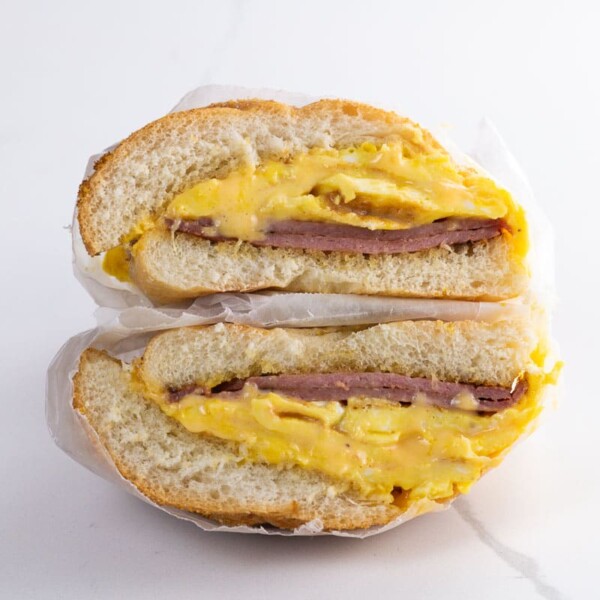 a pork roll egg and cheese sandwich on a kaiser roll wrapped in deli paper