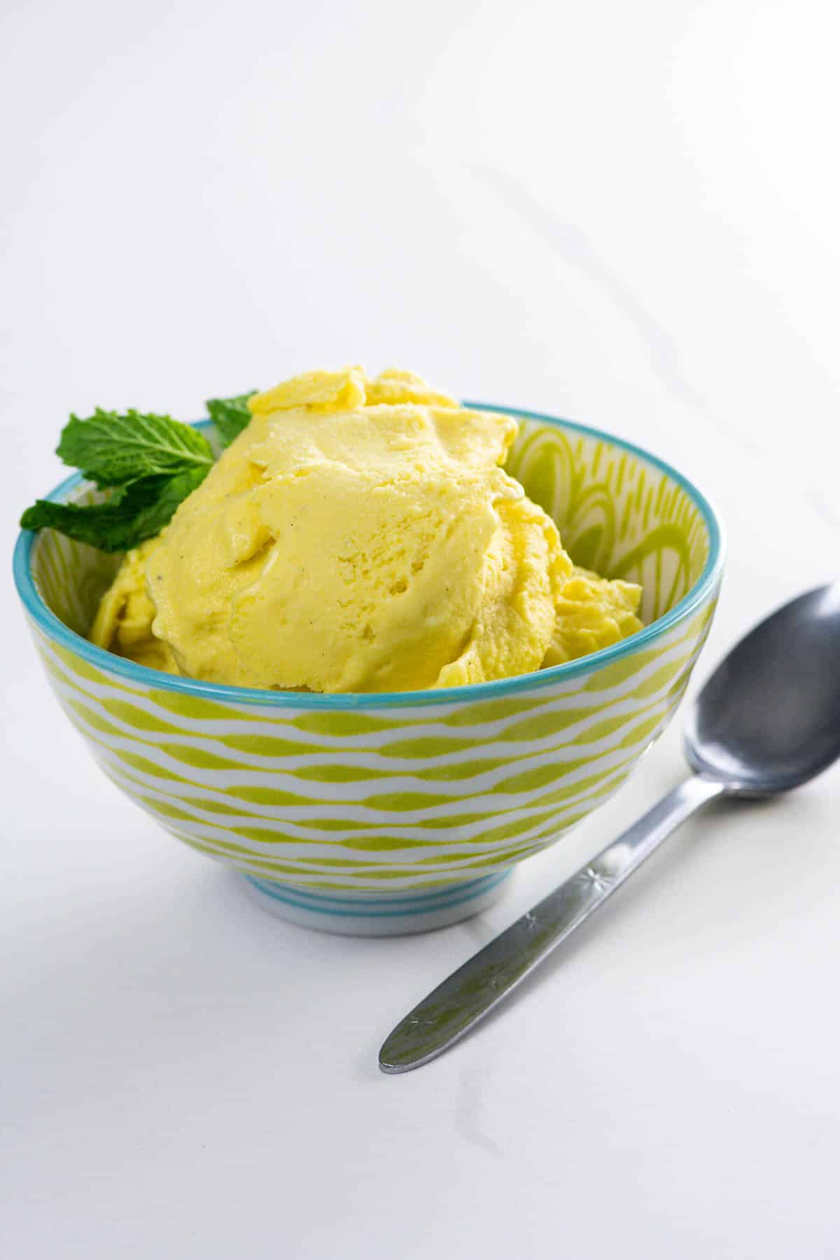 vegan mango ice cream in a bowl with a spoon