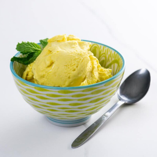 vegan mango ice cream in a bowl with a spoon
