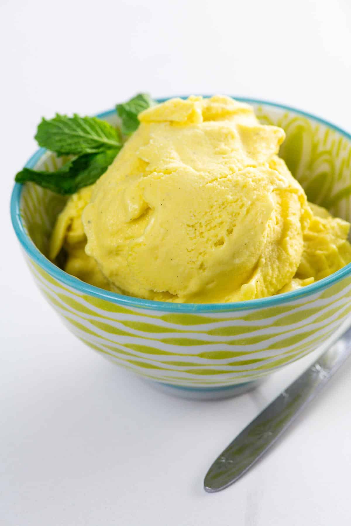 vegan mango ice cream in a bowl with a spoon