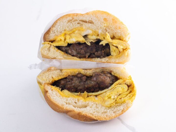 a sausage egg and cheese sandwich on a kaiser roll wrapped in deli paper