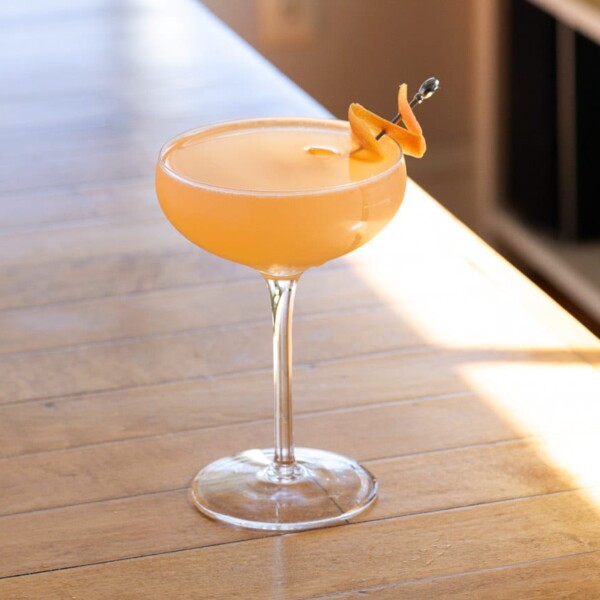 a french blonde cocktail in a coupe glass on a table