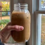 holding a mason jar full of protein coffee
