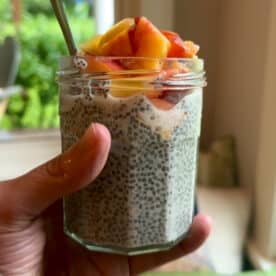 A small jar of chia pudding topped with diced nectarine