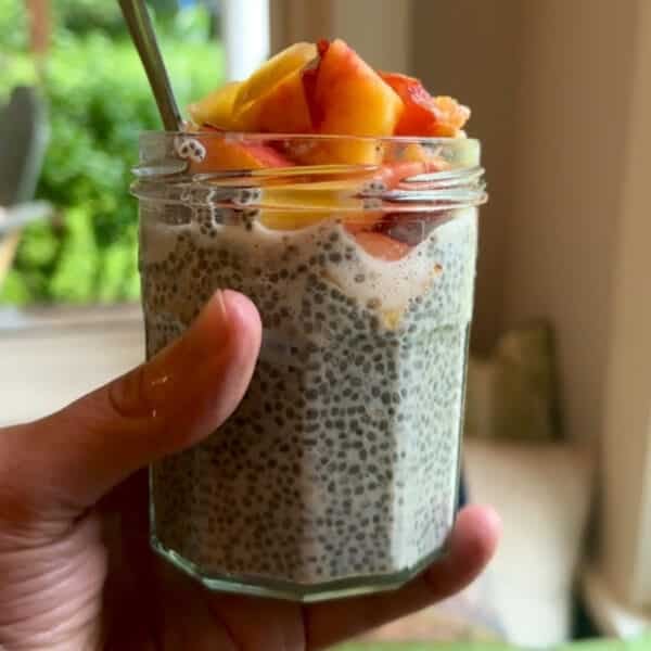 A small jar of chia pudding topped with diced nectarine