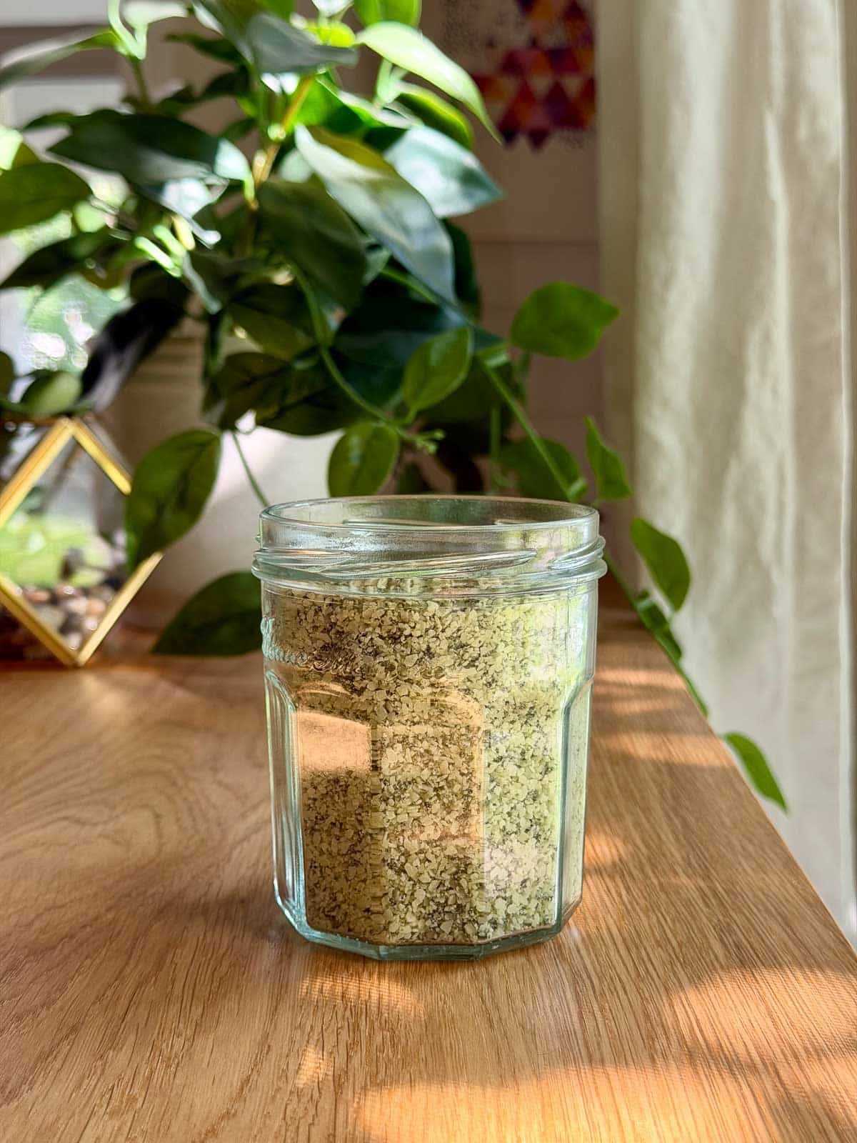 a jar of basil salt on a table