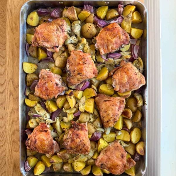 chicken thighs, potatoes, and artichoke hearts in a pan